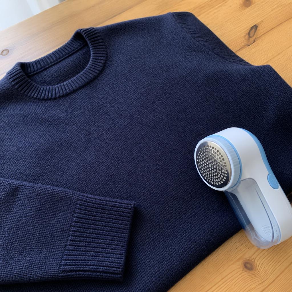 Sweater azul marino limpio junto al quitapelusas ZIANA